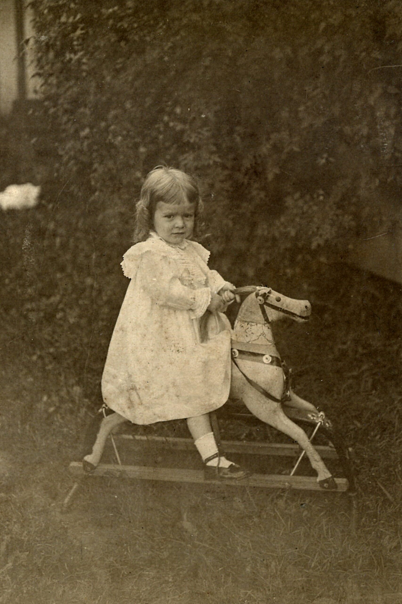 Unknown Persons Gallery - Girl with wooden horse rocker