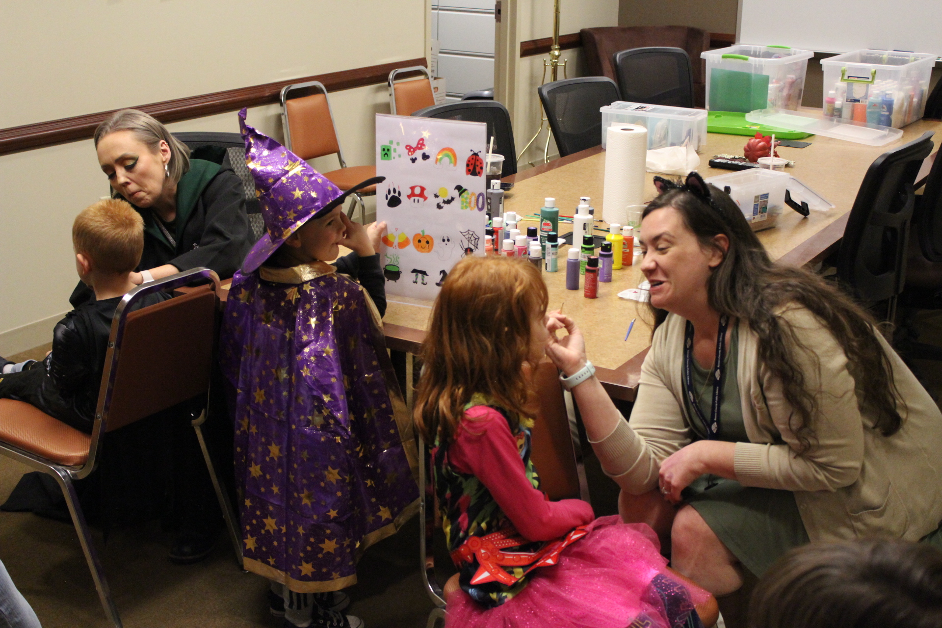 Library Executive Director Jasmyne and Library Programming Coordinator Jess painting costumed children's faces