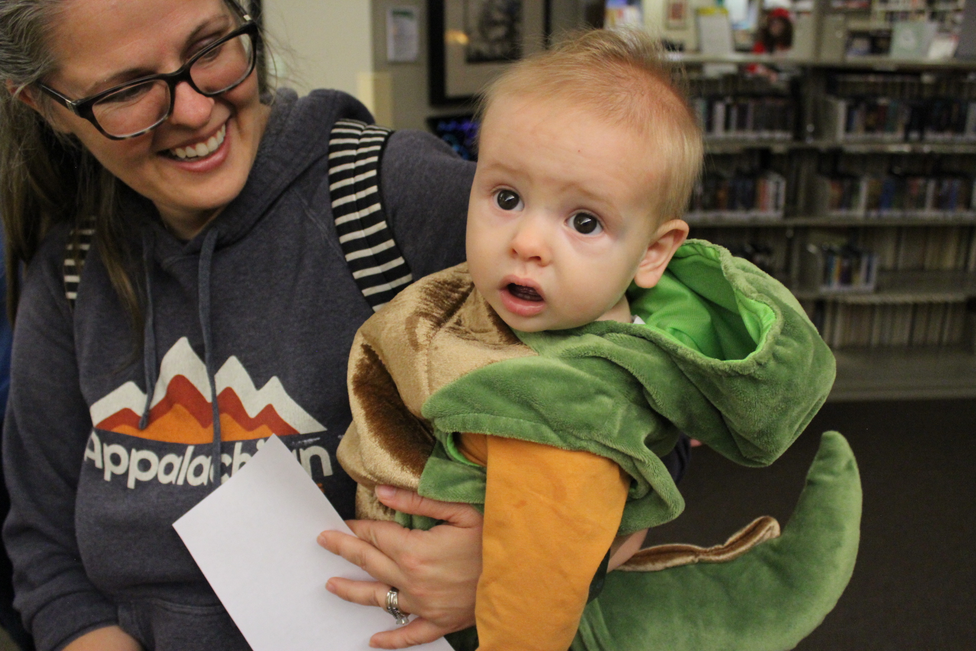 Library patron holding baby dressed as dragon