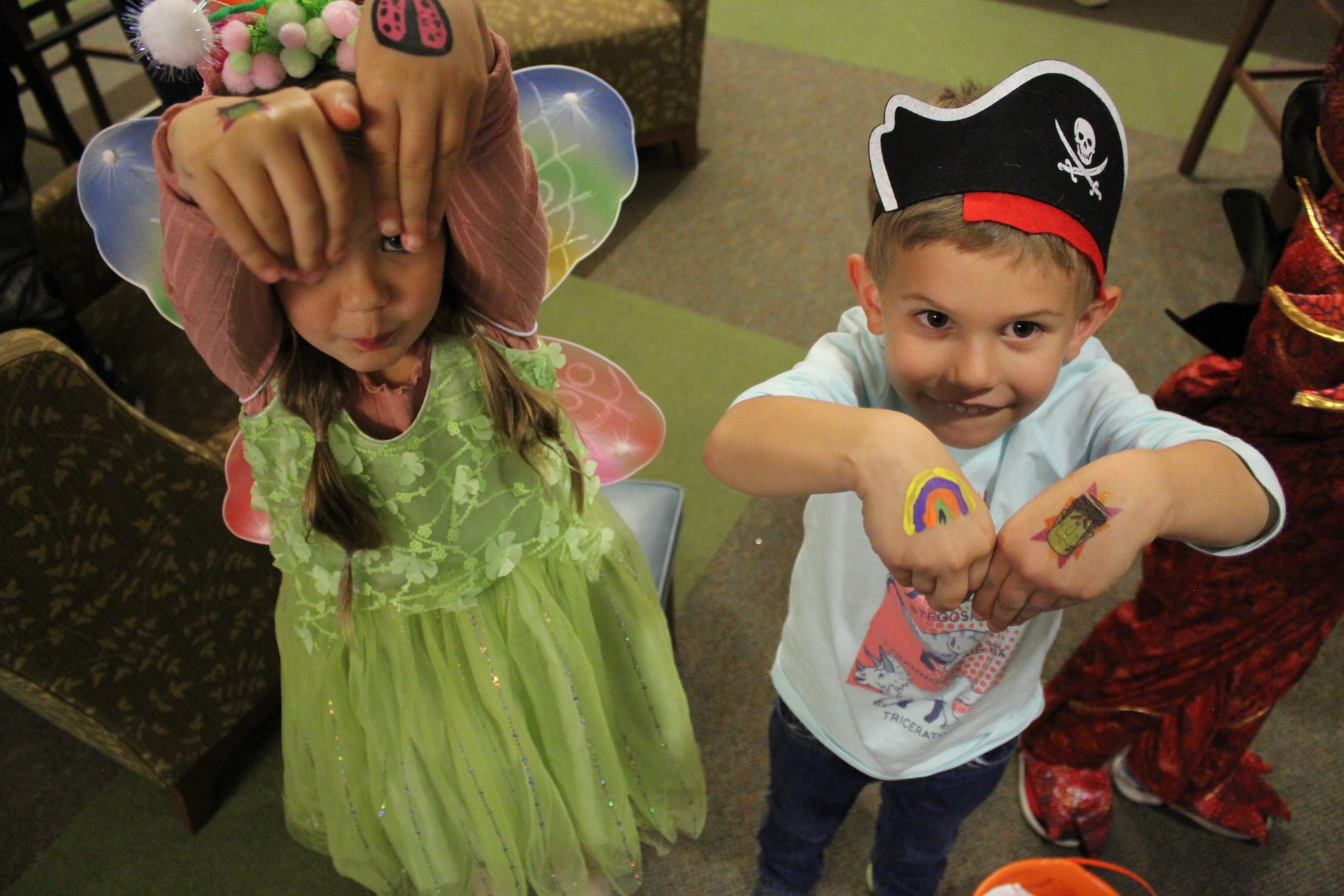 Children in costumes showing off temporary tattoos