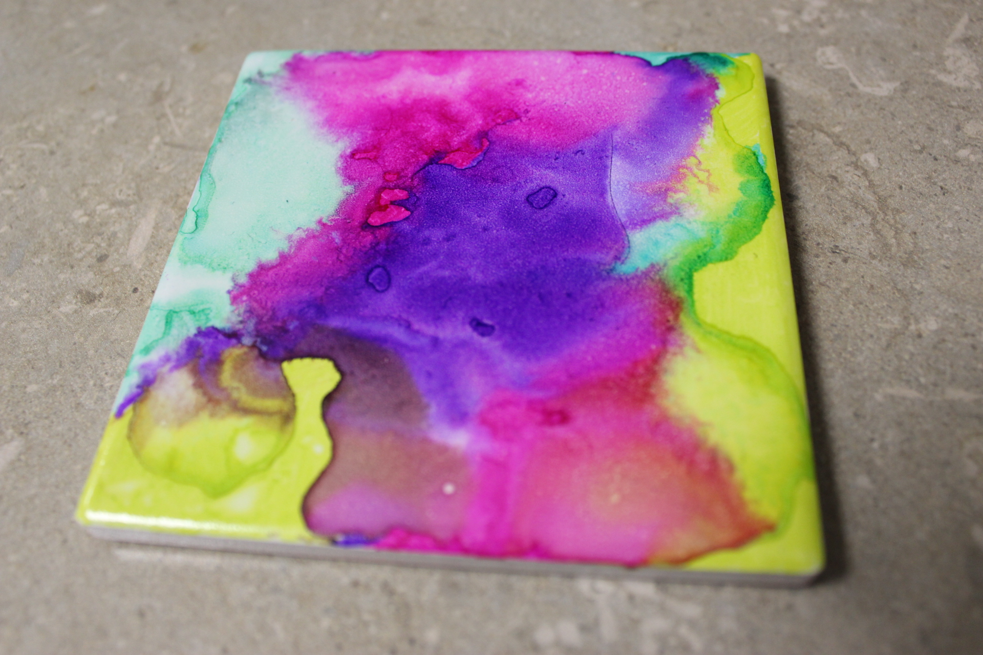 A color-stained square tile coaster
