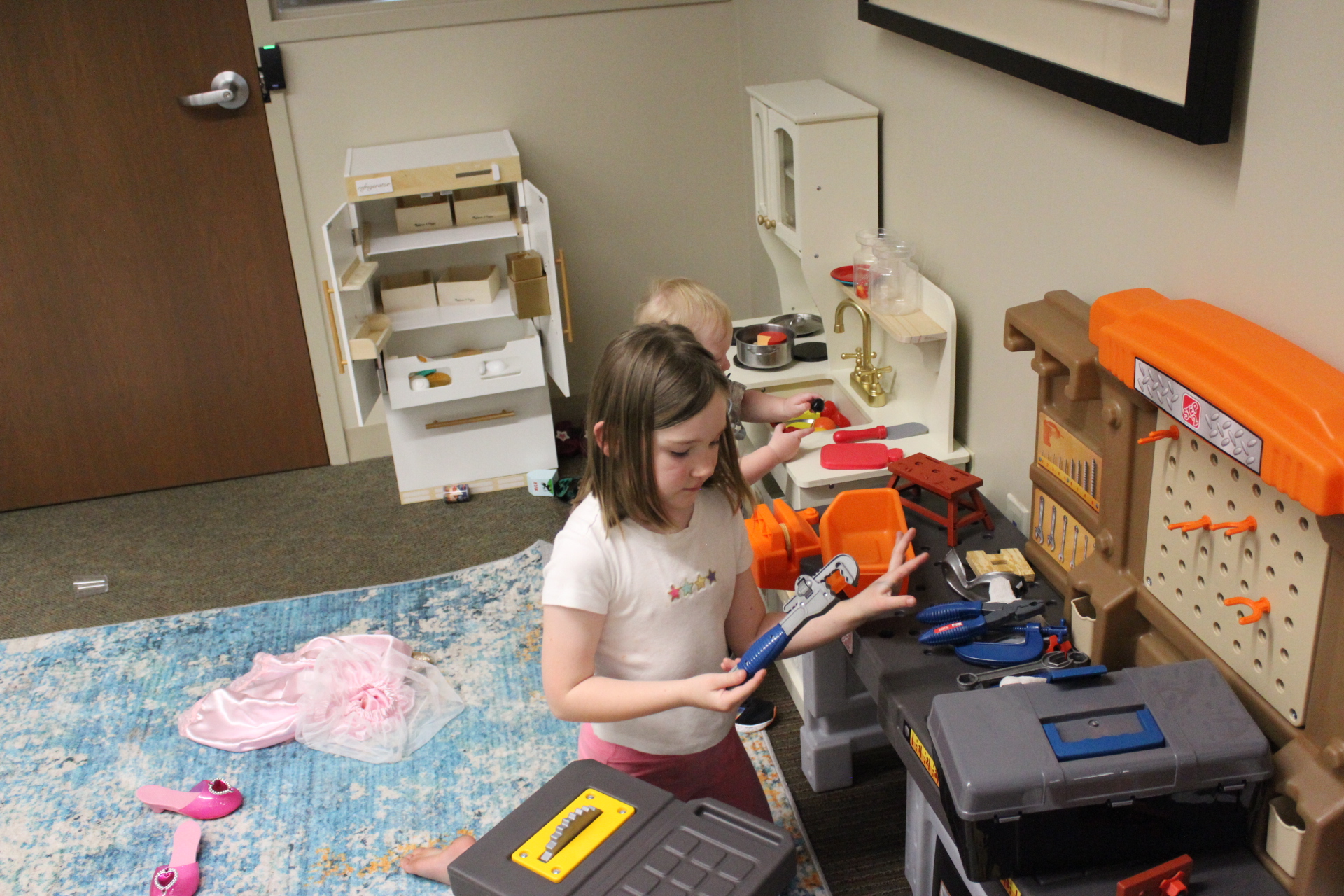 Young girl playing make-believe with toy tools