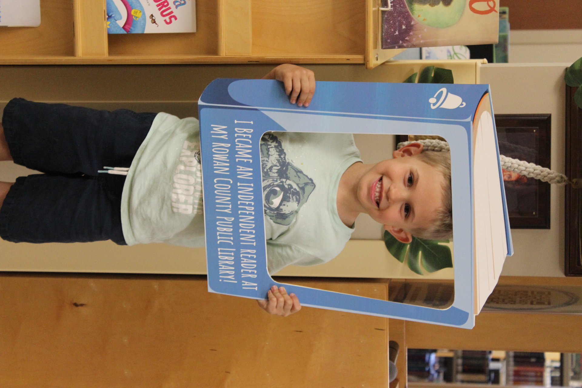 Child holding independent reader frame for picture