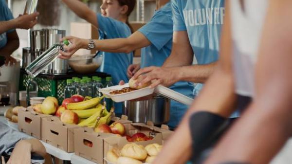 Photo of unidentified volunteers giving out fruits and vegetables