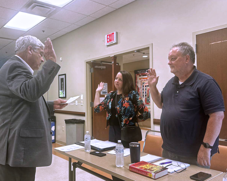 Rowan County Judge-Executive Harry Clark administering the oath of office to new board members Doctor Shana Savard-Hogge and Drew Henderson