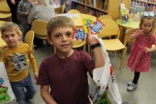 Child displaying Dr. Seuss prizes after winning game