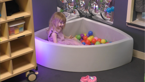 Young girl smiling in a ball pit